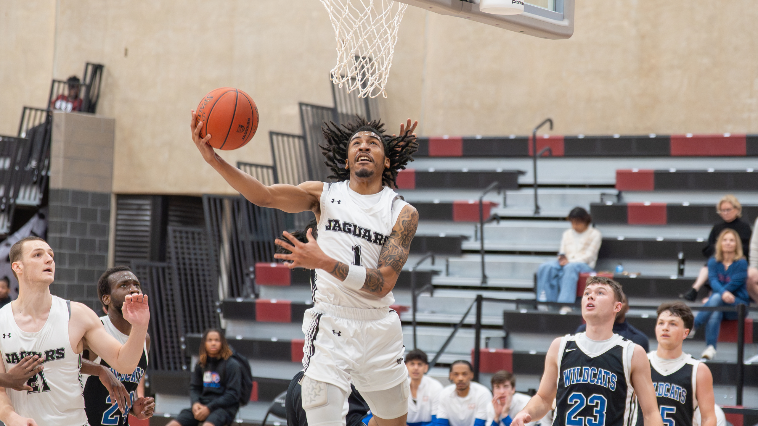 Basketball player with shirt number one jumping to do a one hand dunk.
