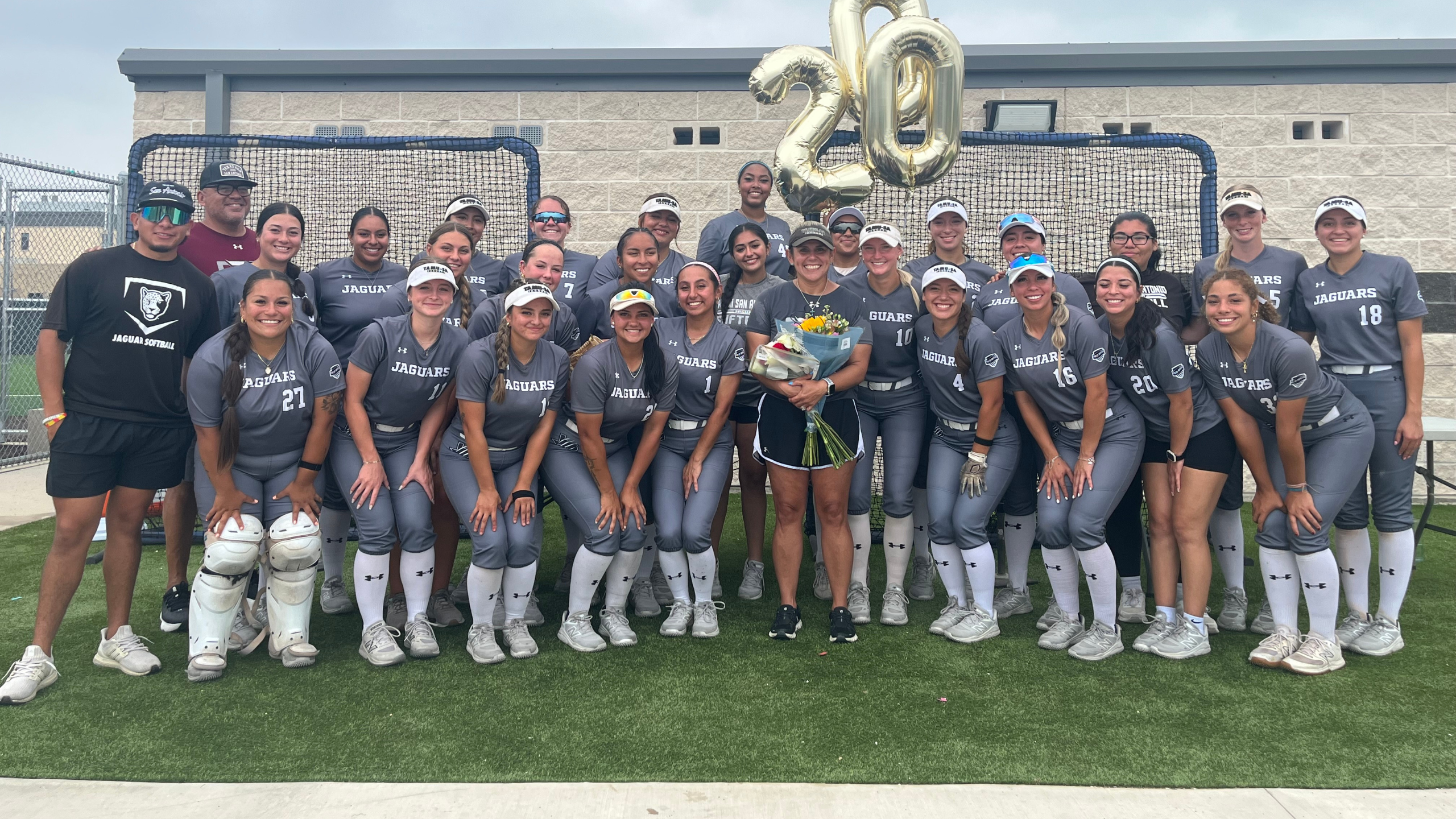 Coach Dame and team pose for a picture celebrating Coach Dame's 200th win. 