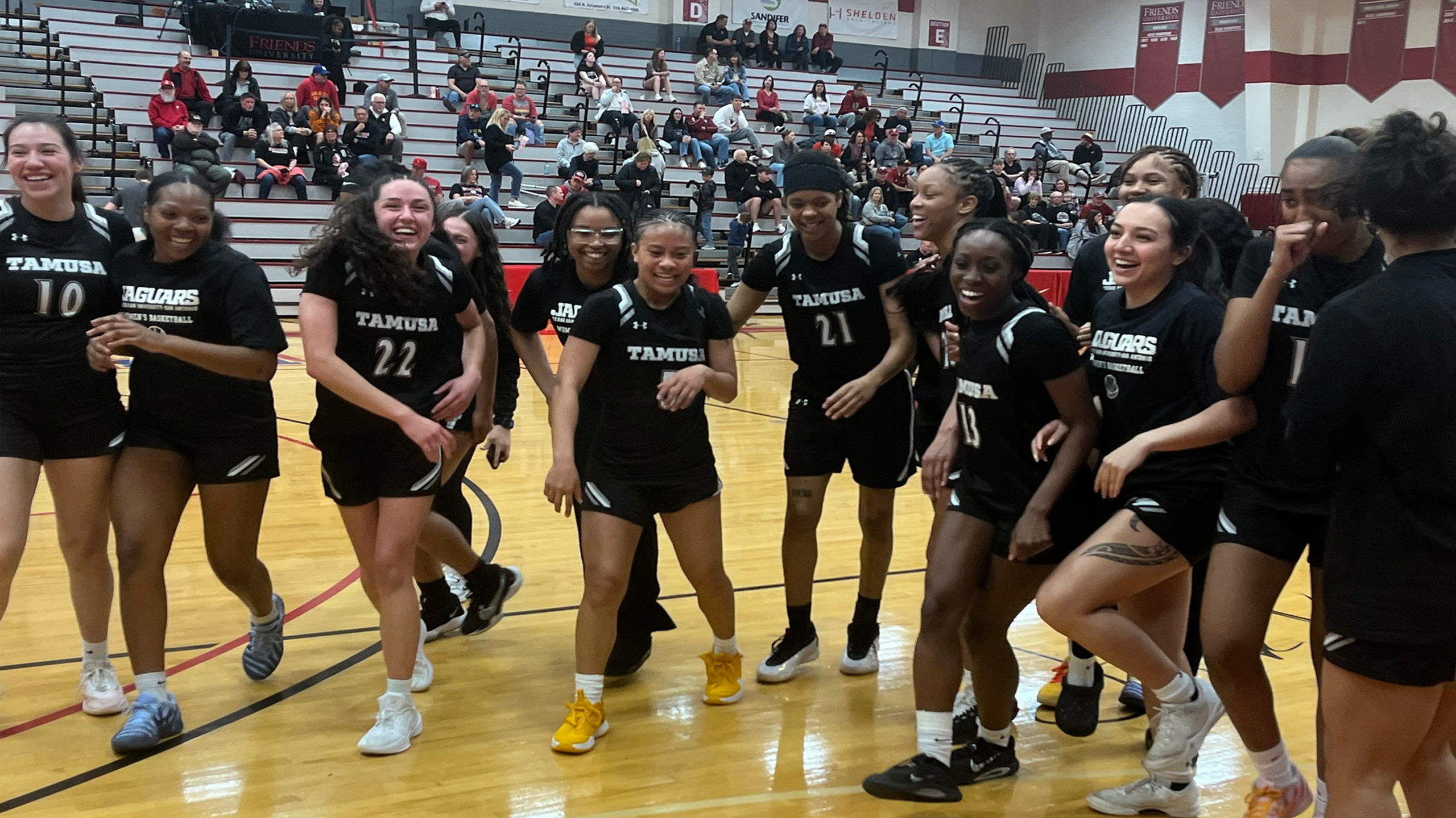 The Jaguar women's basketball team celebrates their NAIA tournament win over Corban University.